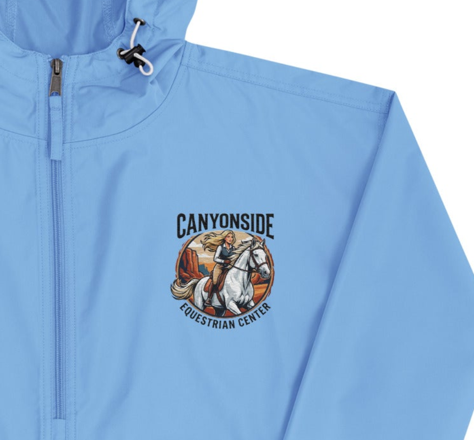 Light blue jacket with a logo of a person riding a horse and text 'Canyonside Equestrian Center'.